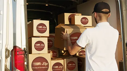A mover loading A-Zip boxes into the back of a truck
